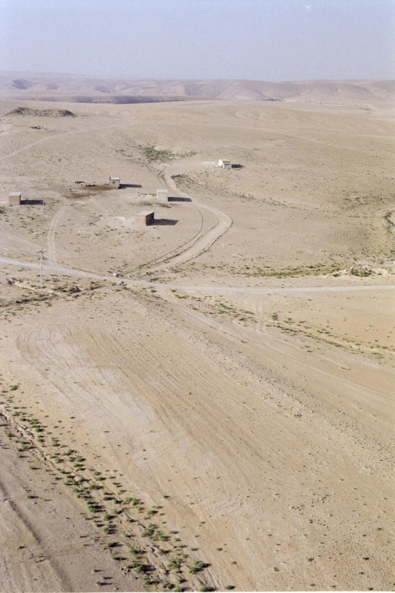 Aerial view of Qasr eth-Thuraiya (background) with the Roman road visible in the ploughed field (foreground). Photograph: Robert Bewley. APAAME_20040532_RHB-0174.